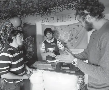  ??  ?? Zero One, centre, the owner of the Sarajevo War Hostel, chats with his guests, Andrew Burns from the U.S., right, and Eren Bastaymaz from Turkey in the hostel’s common room.