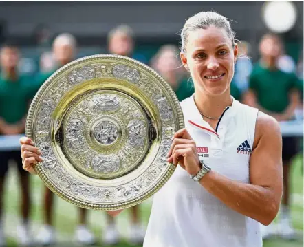  ??  ?? All smiles: Angelique Kerber posing with the trophy after winning the women’s singles final against Serena Williams yesterday. — Reuters