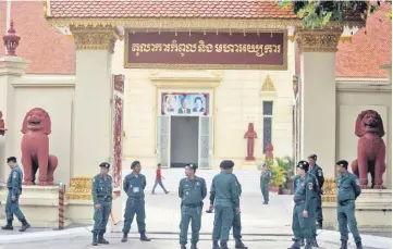  ??  ?? Police officers stand guard at the Supreme Court of Phnom Penh, Cambodia. — Reuters photo