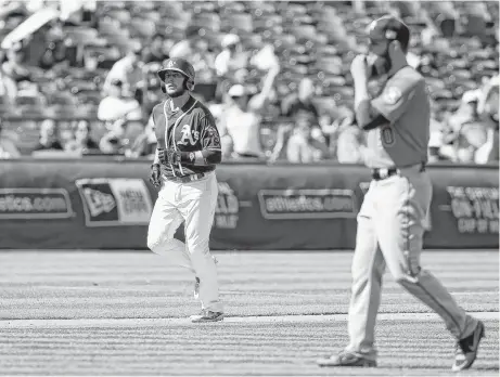  ?? Lachlan Cunningham / Getty Images ?? Oakland’s Jed Lowrie heads home to score after Astros starter Dallas Keuchel, right, walked Matt Chapman with the bases loaded in the sixth inning. Keuchel left with two outs in the inning after giving up three runs.