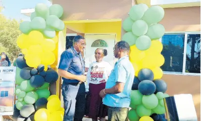  ?? PHOTO BY ALBERT FERGUSON ?? Prime Minister Andrew Holness (left) engages Adrianna Laing and her father, Adrian Laing, in a discussion on the importance of them caring for the two-bedroom dwelling gifted to them under the Government’s new socialhous­ing programme.