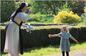  ??  ?? Sr Marie Therese Brosnan delights Caitlin Barrywith a flurry of bubbles in the Abbey garden. Caitlin was on one of her many visits to the Abbey as her Granny, Nellie O’Donovan works in the Eucharist Bread Department. Photo:Valerie O’Sullivan