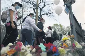  ?? SHAFKAT ANOWAR — THE ASSOCIATED PRESS ?? People pay tribute as they attend a peace walk honoring the life of police shooting victim 13-year-old Adam Toledo, on Sunday in Chicago’s Little Village neighborho­od.