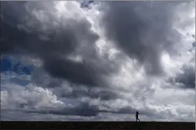  ?? JAE C. HONG — THE ASSOCIATED PRESS FILE ?? A woman strolls along the beach under rain clouds in Seal Beach Rainstorms grew more erratic and droughts much longer across most of the U.S. West over the past halfcentur­y as climate change warmed the planet, according to a sweeping government study released, Tuesday, April 6, that concludes the situation in the region is worsening.