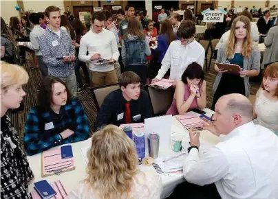  ?? Marisa Wojcik / The Eau Claire Leader-Telegram ?? Volunteer Kurt Kern, lower right, a financial adviser at Ameriprise Financial, explains different options for savings and investment­s to a group of high school seniors on April 5 during the Eau Claire Area Chamber of Commerce’s Real Life Academy at the...