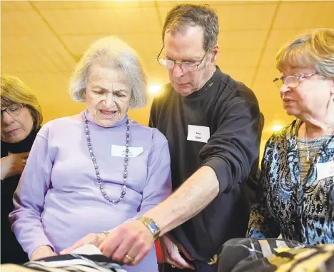  ?? AMY SHORTELL/THE MORNING CALL ?? Audrey Cherney, left, Barry Cohen, center and Lucy Korsky examine the five Czech Torah Scrolls that survived the Holocaust and are now located in the Lehigh Valley.