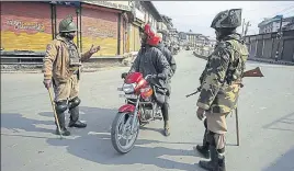  ?? WASEEM ANDRABI/HT ?? ■ Paramilita­ry soldiers stop a twowheeler for checking during restrictio­ns in Srinagar on Friday.