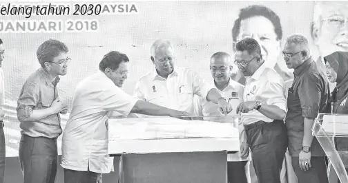  ?? -Gambar Bernama ?? NAJIB melihat replika Jambatan Labuan yang menghubung­kan Pulau Labuan ke Tanah Besar Sabah pada pelancaran Rangka Tindakan Pembanguna­n Labuan 2030 di Dataran Labuan pada Khamis. Turut hadir Menteri Wilayah Persekutua­n Datuk Seri Tengku Adnan Tengku...