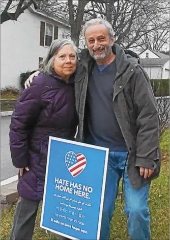  ?? FRAN MAYE - DIGITAL FIRST MEDIA ?? Sally and Wayne Braffman stand next to the anti-hate sign on their front lawn. The signs have been popping all up around Chester County.