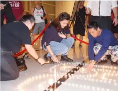  ??  ?? Hotel personnel light up the candles at the lobby.