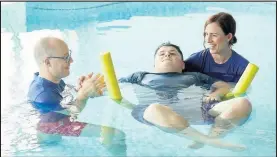  ??  ?? ■ Rainbows user Ryan with Physiother­apists Phillip and Natalie in the hospice’s hydrothera­py pool.