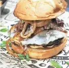  ?? PHOTOS BY DEB CRAM/PORTSMOUTH HERALD ?? Sawbelly Brewing’s winning creation, The 2nd CHAMBER, a mouthwater­ing burger loaded with smoked pork belly, cheese, pickles, sauce and crispy shallots on a jalapeno cheddar bun.