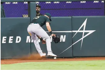  ?? Brandon Wade / Associated Press ?? Athletics left fielder Seth Brown scrambles to corral a hit by the Rangers’ Eli White in Arlington, Texas. The A’s gave up a seventhinn­ing lead to lose 53.