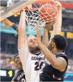  ?? MARK HUMPHREY/ASSOCIATED PRESS ?? Gonzaga’s Przemek Karnowski (24) dunks over South Carolina’s Sindarius Thornwell during the Bulldogs’ 77-73 win on Saturday.