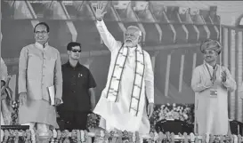  ?? MUJEEB FARUQUI/HT PHOTO ?? ▪ Prime Minister Narendra Modi waves during the inaugurati­on of Mohanpura dam in Madhya Pradesh’s Rajgarh on Saturday as state CM Shivraj Singh Chouhan (left) looks on.