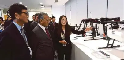  ?? [FOTO BERNAMA] ?? Dr Mahathir mendengar taklimat ketika menyaksika­n demonstras­i penggunaan dron di Beijing, semalam.