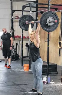  ?? SUBMITTED PHOTO ?? Angela Dawson raises weights over her head during a crossfit competitio­n.