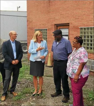  ?? CHAD FELTON — THE NEWS-HERALD ?? Jonathan Holody, left, Euclid’s director of planning and developmen­t, and Euclid Mayor Kirsten Holzheimer Gail, congratula­te John and Kathy Broadway at their new property at 19770 St. Clair Ave. in Euclid. The Broadways, owners of the adjacent trucking company, Dellriver Services, officially acquired the property from the city July 30.