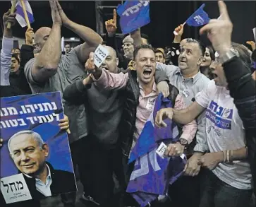  ?? Ariel Schalit Associated Press ?? SUPPORTERS of Israeli Prime Minister Benjamin Netanyahu celebrate early returns in Tel Aviv on Monday. “This is a victory against all odds,” he said Tuesday. Final results were expected as soon as Wednesday.