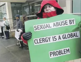  ?? Justin Sullivan Getty Images ?? MELANIE SAKODA demonstrat­es outside the San Francisco Archdioces­e in 2010 in protest of the Catholic Church’s efforts to cover up its sex abuse scandal.