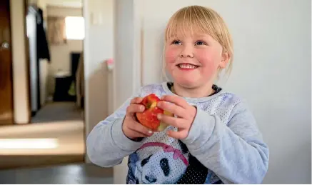  ?? PHOTO: JOSEPH JOHNSON/FAIRFAX NZ ?? Izzy Foulds, 4, is learning to appreciate the benefits of an apple a day.