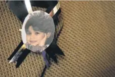  ?? Denver Post file ?? Atadero wore a pin with Jaryd’s photo at 2003 memorial service for the 3-year-old.