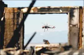  ?? Allen J. Schaben Los Angeles Times ?? A FIREFIGHTI­NG helicopter flies above an Anaheim fire in 2017. A fixed-wing aircraft trial program will give firefighte­rs access to real-time data on wildfires.