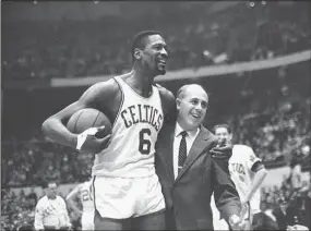  ?? Bill Chaplis / Associated Press ?? Bill Russel, left, star of the Boston Celtics, is congratula­ted by coach Arnold “Red” Auerbach after scoring his 10,000th point in the NBA game against the Baltimore Bullets in 1964 in Boston Garden.