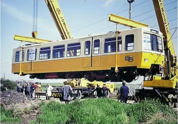  ??  ?? Top: One of the two parts of Metrocar No. 4001 is unloaded at the test track for the system, while (left) the completed unit sits after delivery from Metro-Cammell in Birmingham. The 1,500V DC overhead line equipment was swung into place later.