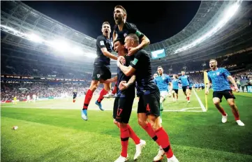  ??  ?? Croatia’s Mario Mandzukic celebrates with teammates after scoring the second and winning goal against England in their semi-final match at Luzhniki Stadium in Moscow. — Reuters photo