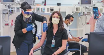  ?? Picture: AFP ?? JAB. A licensed vocational nurse gives registered nurse Janey Willis the Pfizer-BioNTech Covid-19 vaccine shot at Rady Children’s Hospital in California on Tuesday.