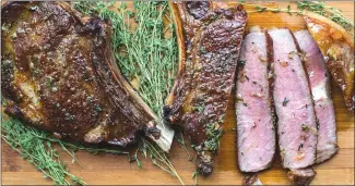  ?? Associated Press photo ?? This photo shows ribeye steaks with thyme-garlic butter in New York. This is a classy take on a restaurant-quality steak dinner.