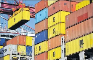  ?? AP PHOTO ?? A container is loaded onto a cargo ship at a port in Qingdao in east China’s Shandong province. China has accused the United States on Thursday of using pressure tactics and blackmail in threatenin­g to impose tariffs on hundreds of billions of dollars...