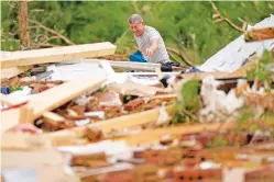  ?? GEORGE WALKER IV/THE ASSOCIATED PRESS ?? John Bernhardt picks up debris at his stormed-damaged home Thursday in Columbia, Tenn. A wave of dangerous storms hit the South this week.