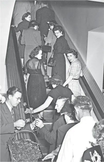  ?? THE COMMERCIAL APPEAL FILES ?? Customers found the new electric stairs at Goldsmith's a grand thing in October 1950. Posies were presented to all who used the moving stairs. In addition to installing the stairs, the store has enlarged its first floor selling space.