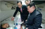  ?? KOREAN CENTRAL NEWS AGENCY ?? Aboard the China-bound train, DPRK leader Kim Jong-un and other officials wish one of the survivors well at the Pyongyang railway station before the trip back home.