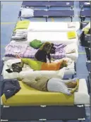  ?? AP PHOTO ?? People prepare to spend the night in a makeshift camp set up inside a gymnasium following an earthquake in Amatrice, Italy.