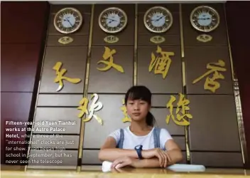  ??  ?? Fifteen-year-old Yuan Tianhui works at the Astro Palace
Hotel, where three of the “internatio­nal” clocks are just for show. Yuan began high school in September, but has never seen the telescope