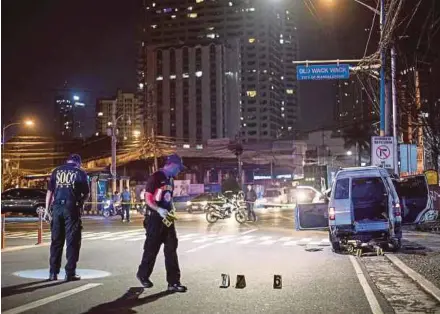  ?? AFP PIC ?? Police at the scene of the shooting in Mandaluyon­g city, Manila, yesterday.