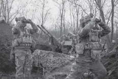  ?? FRANCE PRESSE AGENCE ?? Ukrainian servicemen (L and R) look on with binoculars next to another (C) sitting on an anti-air gun near Bakhmut.