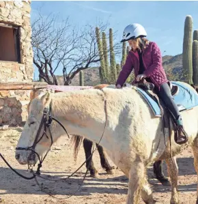  ?? TNS ?? Writer Bill Fink’s niece, Esme Charles, 8, gets comfortabl­e in the saddle, much as her mother did as a child when the Fink family visited Tanque Verde years ago.