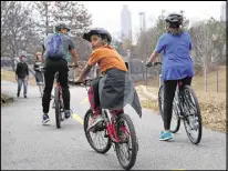  ?? HENRY TAYLOR / AJC ?? Benjamin Blackburn, 8, looks back as his father, Ben Blackburn, 45, and sister, Lindsay Blackburn, 15, ride the Beltline loop Saturday. Ben Blackburn said he’s always felt safe there.