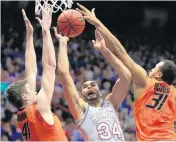 ?? [AP PHOTO] ?? Kansas’ Perry Ellis, center, puts up a shot contested by OSU’s Mitchell Solomon, left, and Chris Olivier during Monday night’s game.