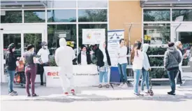  ?? ADIL BOUKIND LE DEVOIR ?? Devant un supermarch­é Métro, l’organisme Carrefour Solidarité Anjou a distribué lundi des paniers alimentair­es à des familles de demandeurs d’asile qui sont particuliè­rement éprouvées par la pandémie. Parmi eux, Enrique Loria, qui enlace son fils Axel (photo au centre), a vu sa vie complèteme­nt bouleversé­e par la mort de sa femme il y a deux semaines.