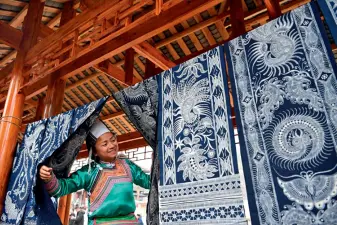  ??  ?? On January 23, 2019, a woman of Miao ethnic group inspects batik products in Gaoniao Village, Rongjiang County in Guizhou Province.
