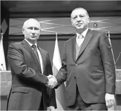  ??  ?? Erdogan (right) shaking hands with Putin during a joint press conference after their meeting at the Presidenti­al Complex in Ankara. — AFP photo