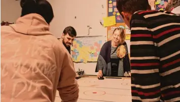  ?? Fotos: Christian Kirstges ?? Nadine Erath und Tobias Ullmann spielen mit Jugendlich­en noch eine Runde Airhockey im Jugendtref­f. Essen und Getränke sind zum Abschied gratis, die Vorräte müssen aufgebrauc­ht werden.