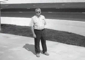  ??  ?? The late John Chisholm stands near the banking of Riverside Speedway, which he owned not once but twice.