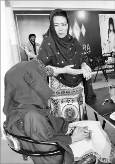  ??  ?? Hameeda Ali Hazara (top left), who manages the ‘Hazara’ restaurant, chats with customers at the eatery.