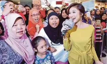  ??  ?? Ayda menghiburk­an peminat pada majlis hari raya bersama produk Gintell di Wangsa Walk, Wangsa Maju.